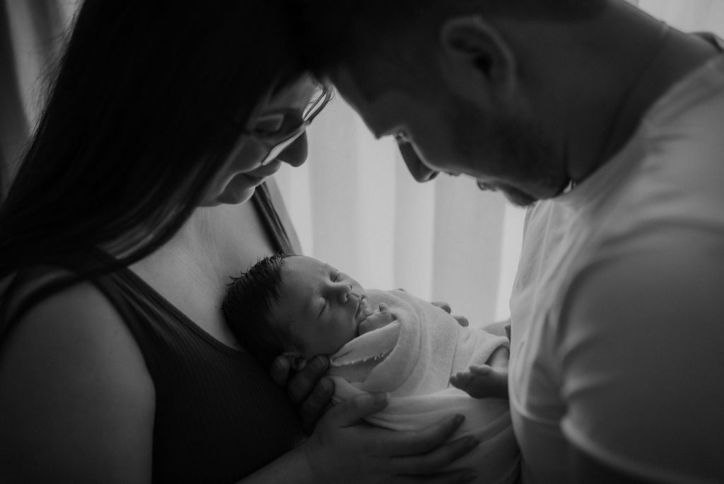 photography of family with newborn son