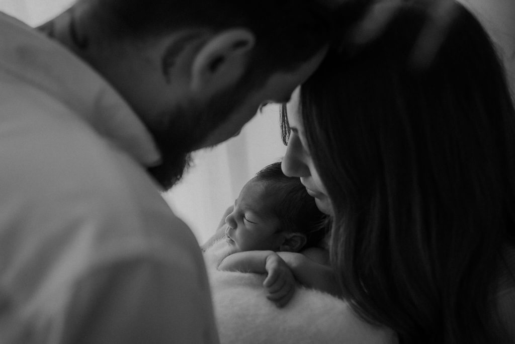 mum and dad posing with baby girl